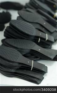 Black shoe soles in a factory