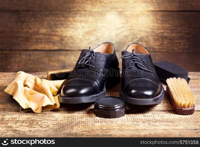 black shoes with care accessories on a wooden background