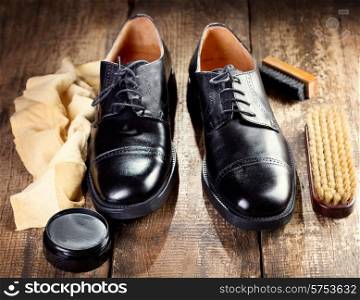 black shoes with care accessories on a wooden background
