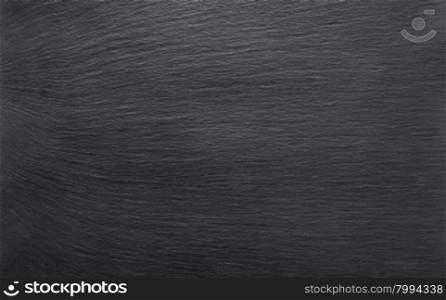Black slate background or textured stony table close-up