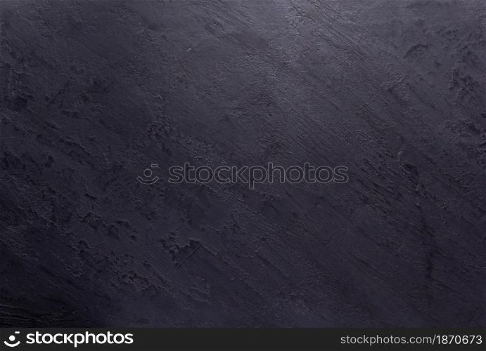 Black slate stone background texture. Putty or plaster wall surface