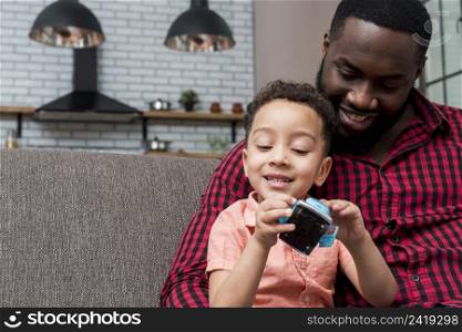 black son father sitting with toy car