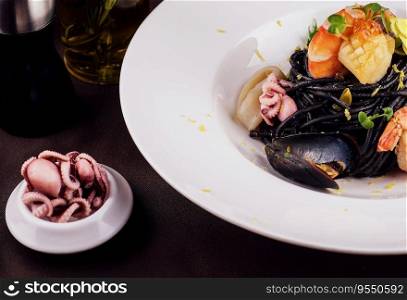 Black spaghetti with seafood on white plate