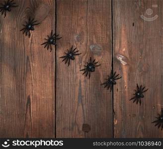 black spider figurines on brown wooden background, Halloween holiday
