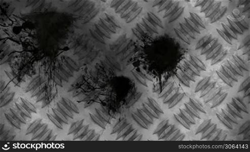 Black splatters over metal plate