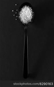 Black spoon of white sugar