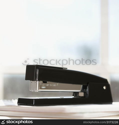 Black stapler with window in background.