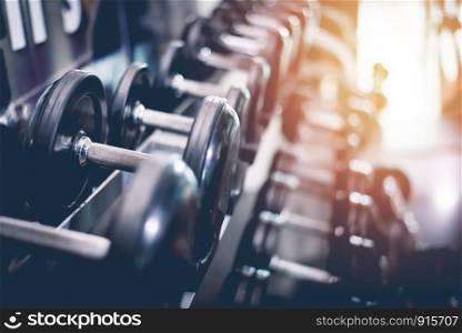 Black steel dumbbell set. Close up of dumbbells on rack in sport fitness center. Workout training and fitness gym concept. Healthy and well being concept. Sport equipment and tool theme.