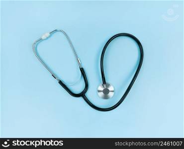Black stethoscope on a soft blue background. Simple flat lay.. Black stethoscope on soft blue background. Simple flat lay.