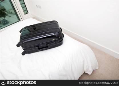 Black suitcase on bed