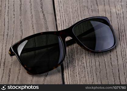 Black Sunglasses On a wooden background. Black Sunglasses On a wooden