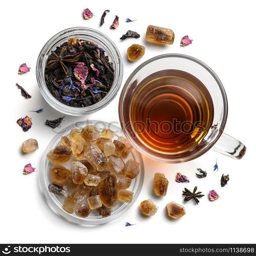 Black tea with natural flavors and a cup. Top view on white background.. Black tea with natural flavors and a cup. Top view on white background