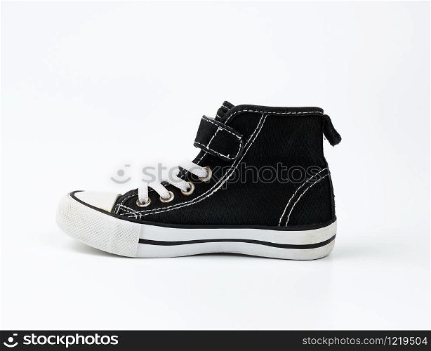 black textile sneaker with white tied shoelaces on a white background, shoes stand sideways
