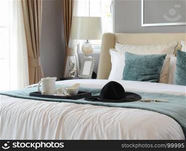 black tray of tea set with white and green pillows in classic style bedroom