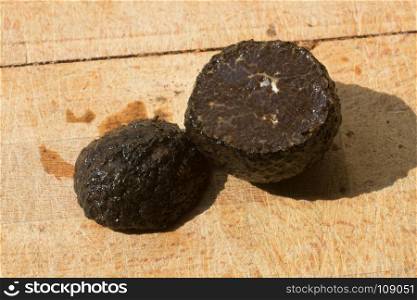 black truffle isolated on a wooden cutting board