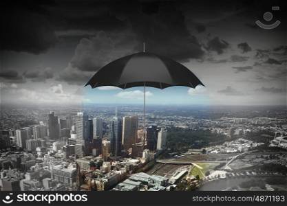 Black umbrella in sky. Old black umbrella against rainy sky above city