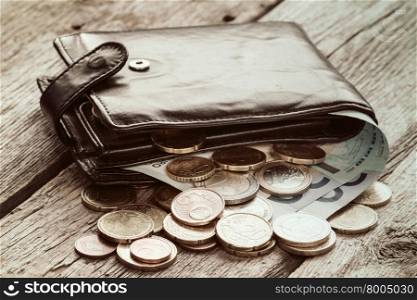Black wallet with euro currency on the wooden background
