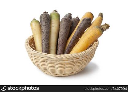 Black, white and yellow carrots in a basket on white background