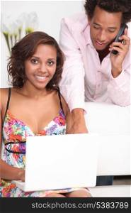 black woman doing computer and his boyfriend at phone