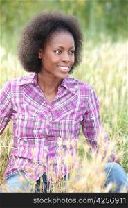 black woman sitting and relaxing in a field