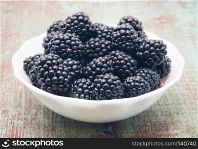 Blackberries in a bowl on wooden table