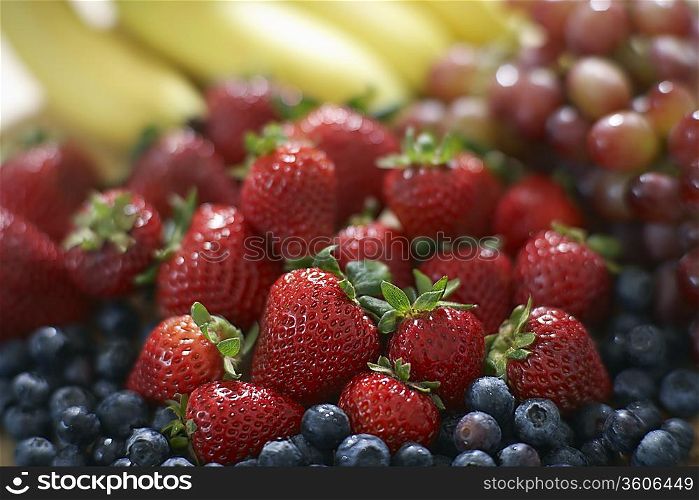 Blackberries strawberries grapes and bananas close-up selective focus