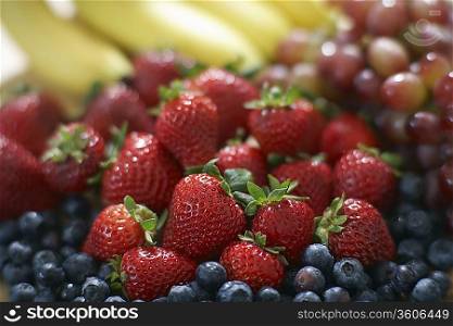 Blackberries strawberries grapes and bananas close-up selective focus