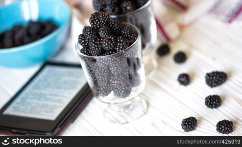 blackberry fruit in transparent glass on a white wooden table
