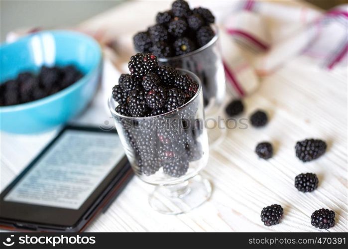 blackberry fruit in transparent glass on a white wooden table