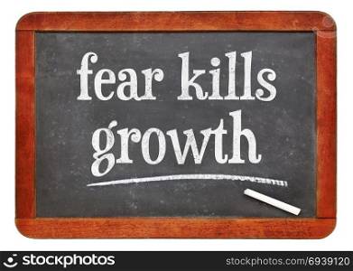 blackboard. Fear kills growth message - white chalk text on a vintage slate blackboard