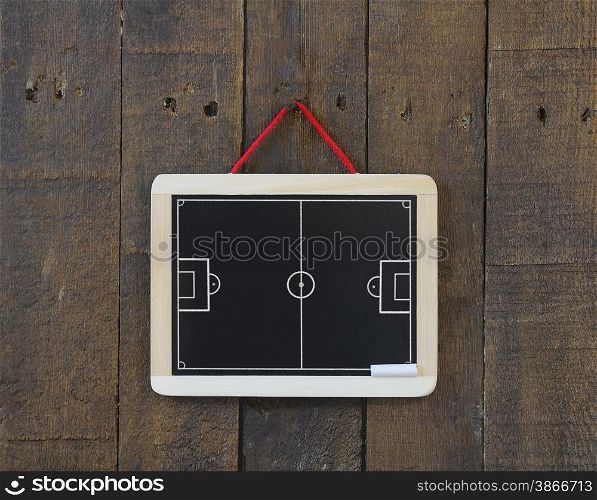 Blackboard hanging on a wall with football field.