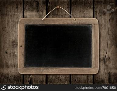 Blackboard on a old dark wood wall background texture. Blackboard on a dark wood wall background