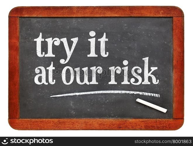 blackboard. try at out risk marketing slogan - white chalk text on a vintage slate blackboard