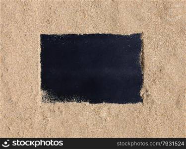Blackboard with copy space on beach sand.