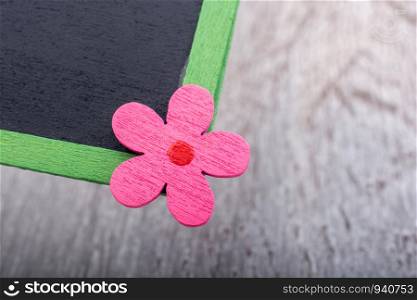 Blackboard with floral icon placed on green grass ground