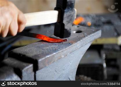 Blacksmith forges a hot spear on the anvil