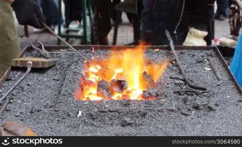 blacksmith heats fire thin iron rod
