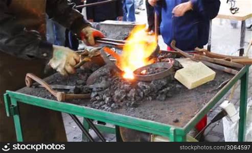 blacksmith takes from fire two hot metal rings