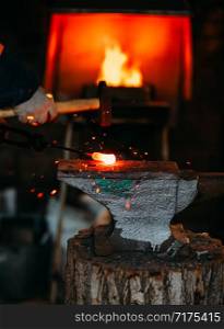 Blacksmith workshop. The blacksmith works on the anvil with a hot metal billet.. Blacksmith workshop. The blacksmith works on the anvil with a hot metal billet