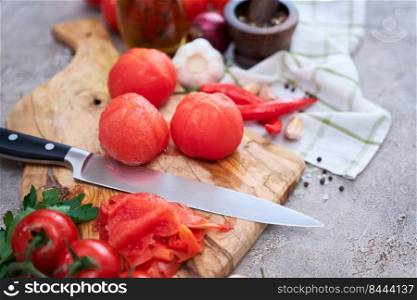 blanched peeled tomatoes on wooden cutting board at domestic kitchen.. blanched peeled tomatoes on wooden cutting board at domestic kitchen
