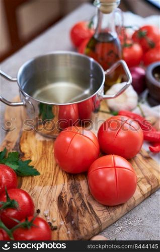blanched tomatoes on wooden cutting board ready for peeling at domestic kitchen.. blanched tomatoes on wooden cutting board ready for peeling at domestic kitchen