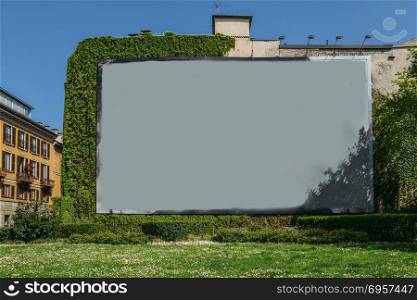 Blank advertisement space on wall next to grass and vines.. Blank advertisement space on wall next to grass and vines