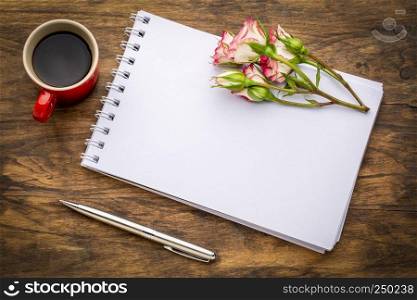 blank art sketchbook with flowers and coffee on a grunge wooden table