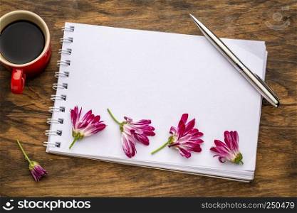 blank art sketchbook with flowers and coffee on a grunge wooden table