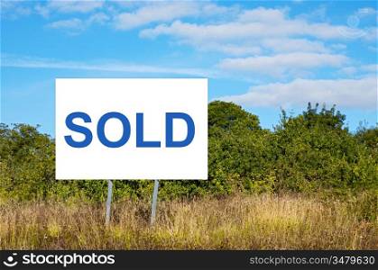 Blank billboard with message &acute;sold&acute; in the field