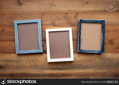 Blank black, gray and white wooden frames on vintage wood background, template