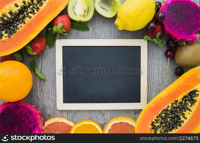 blank blackboard surrounded by summer fruits