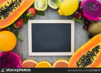 blank blackboard surrounded by summer fruits