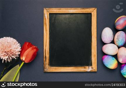 blank blackboard with red tulip chrysanthemum easter eggs black background