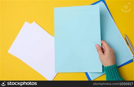 blank blue sheets and female hand, top view. Text writing, list
